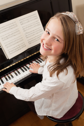 Photo of a young girl playing the piano at home.